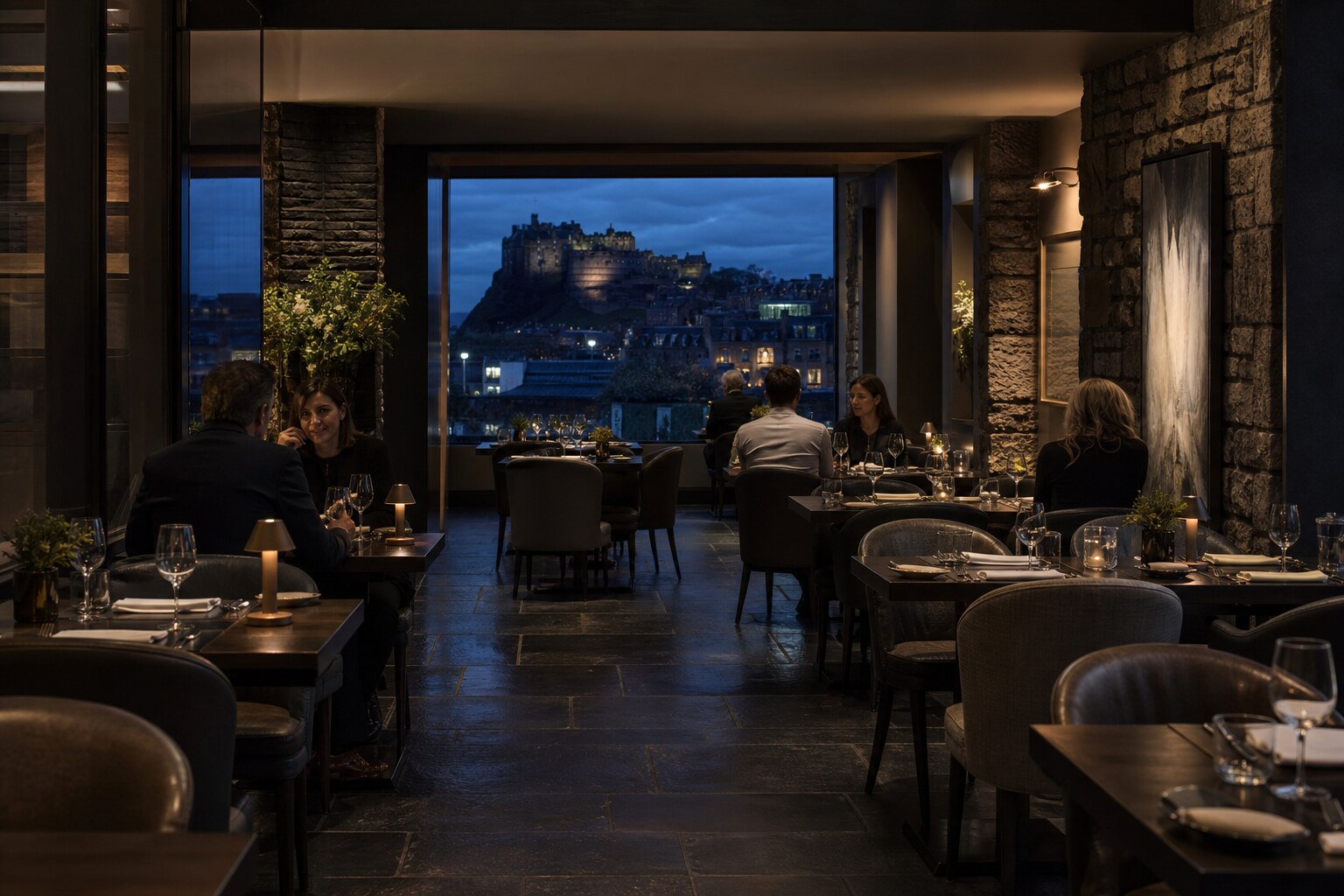 The stone and slate dining room with an evening castle view